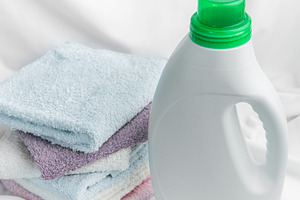 Laundry detergent bottle with clean folded towels