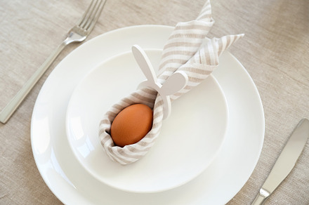 Easter egg with rabbit ears made of napkin on white plate, a Holiday Photo by photoguns