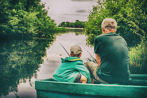 grandfather and boy fishing together