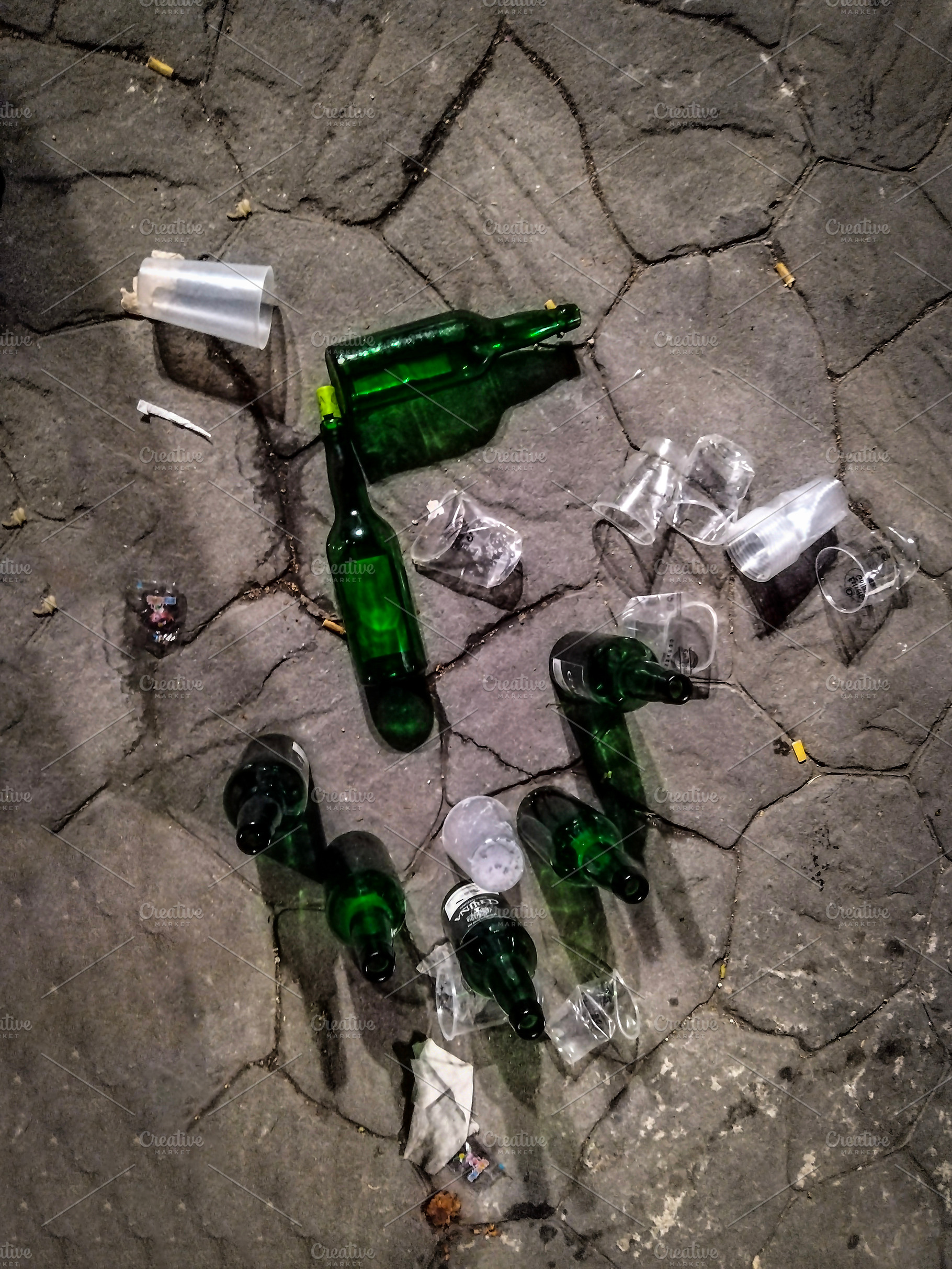 Broken glass bottles scattered on cobblestone, a Food & Drink Photo by DanFLCreativo