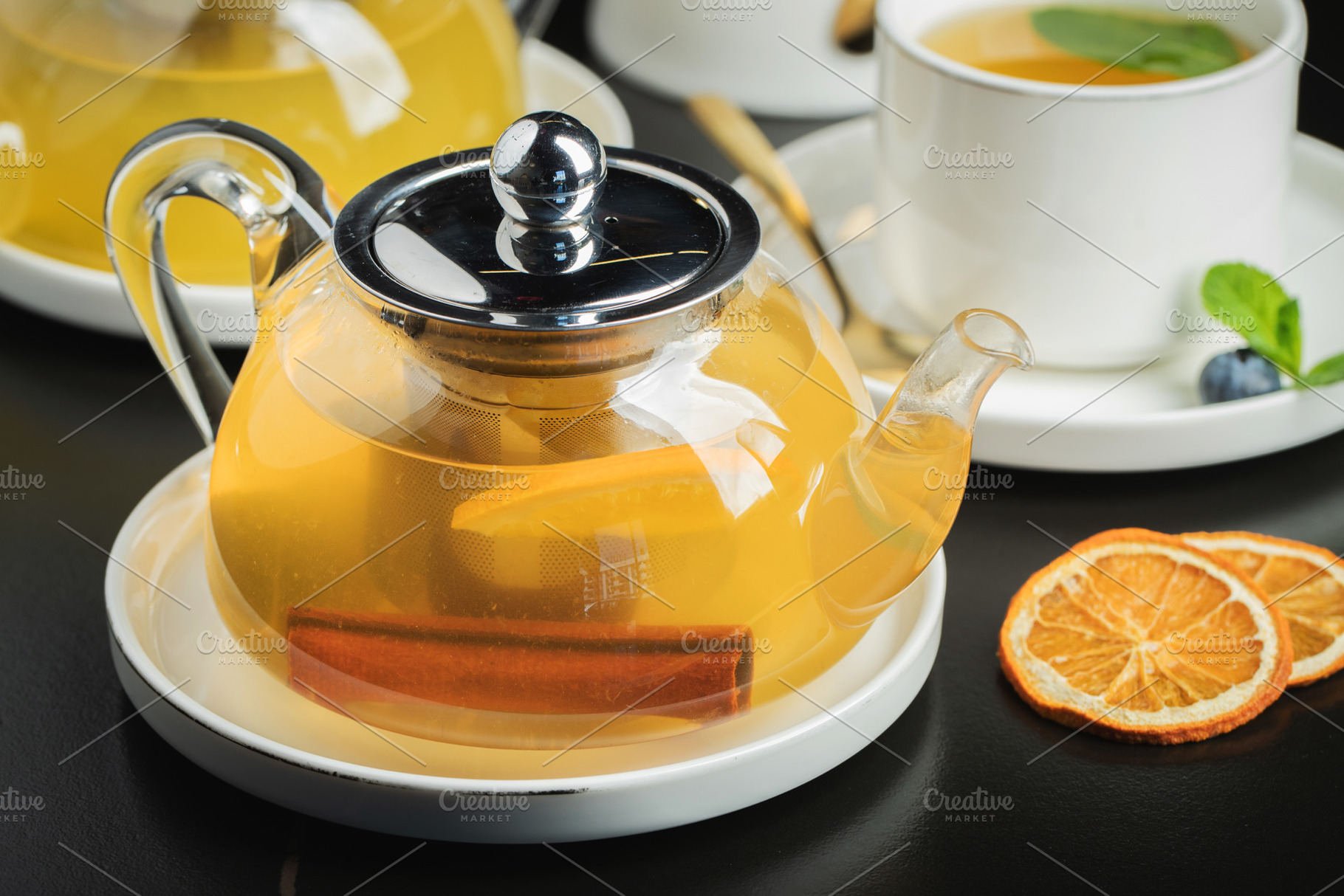 Fruit tea with mango and mint in a glass teapot on the table, a Food & Drink Photo by Budarinphoto