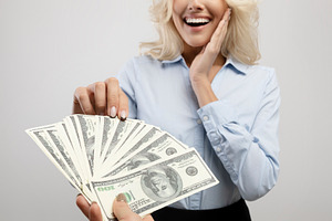 Corruption concept. Female hand giving money to surprised businesswoman on ligh, a Photo by Prostock-Studio