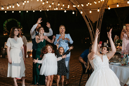 bride in a white dress throws a wedding bouquet