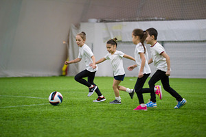 Children playing football indoors
