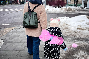 Mother and child walking on a snowy city street in winter, child with pink butt, a Photo by AS photostudio