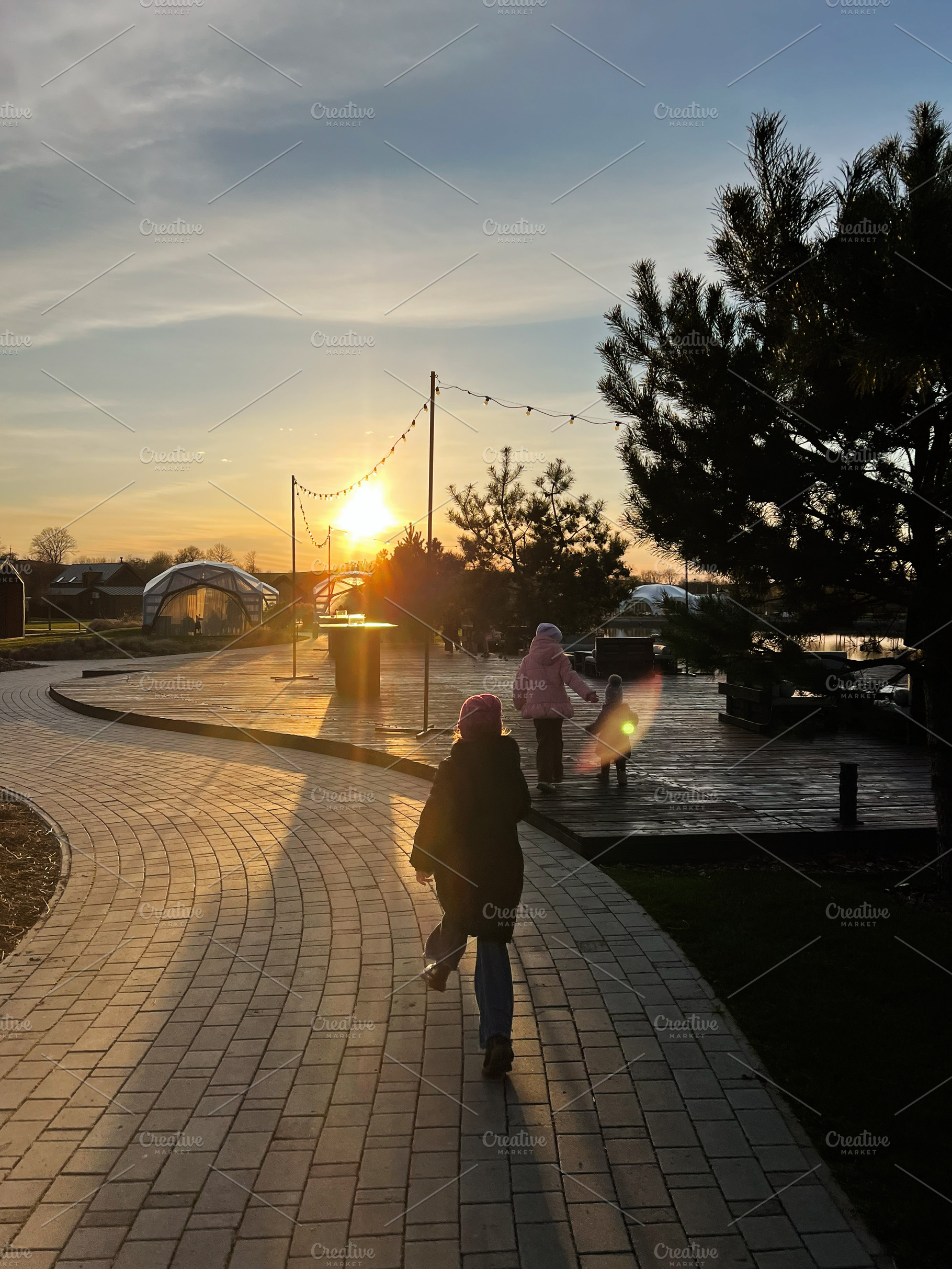 Family walking along a park trail at sunset in a peaceful environment, a Photo by AS photostudio