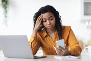 Upset black woman looking at smartphone screen, a Photo by Prostock-Studio (Thumbnail 2 of 2)