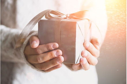 Female hands holding gift box. Copy