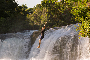 Adventure Traveller Jumping Off Waterfall In Belize, a Person Photo by THP Creative