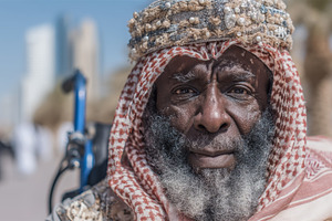 Elderly arabian man in traditional attire outdoors with urban background and br, a Photo by AS photostudio