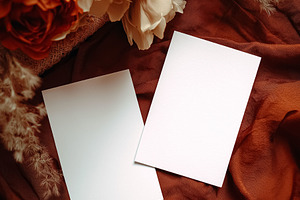 Blank cards mockup on earthy silk fabric with dried flowers, representing rusti, a Holiday Photo by Studio ANNA