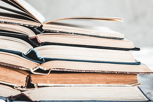 Opened books in a stack on a light featuring grunge, retro, and vintage