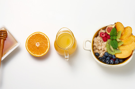 plate with oatmeal and fruit, half a ripe orange and freshly squ, a Food & Drink Photo by ndanko