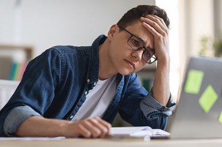 Job Burnout. Depressed Young Manager Looking At Laptop While Working In Office