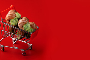 Miniature shopping cart filled with snails against a bold red ba, a Food & Drink Photo by Ales Munt