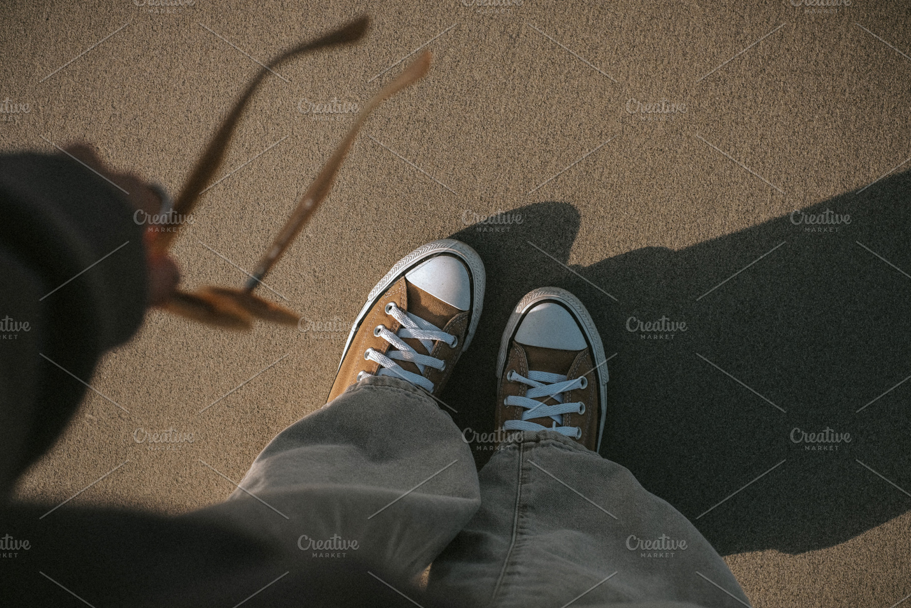 Female feet in sneakers on sand, a Person Photo by Valeriia Miller