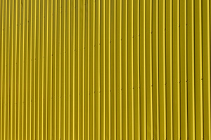 Bright texture of vertical metal siding painted yellow., a Background Photo by ndanko