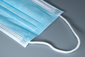 Close-up macro shot of a blue disposable medical face mask on a grey background, a Health & Medical Photo by Rohan Photography
