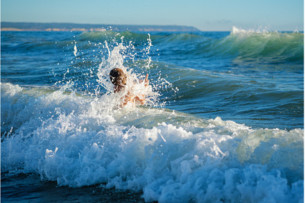Boy having fun jumping in ocean sea, a Person Photo by f9photos
