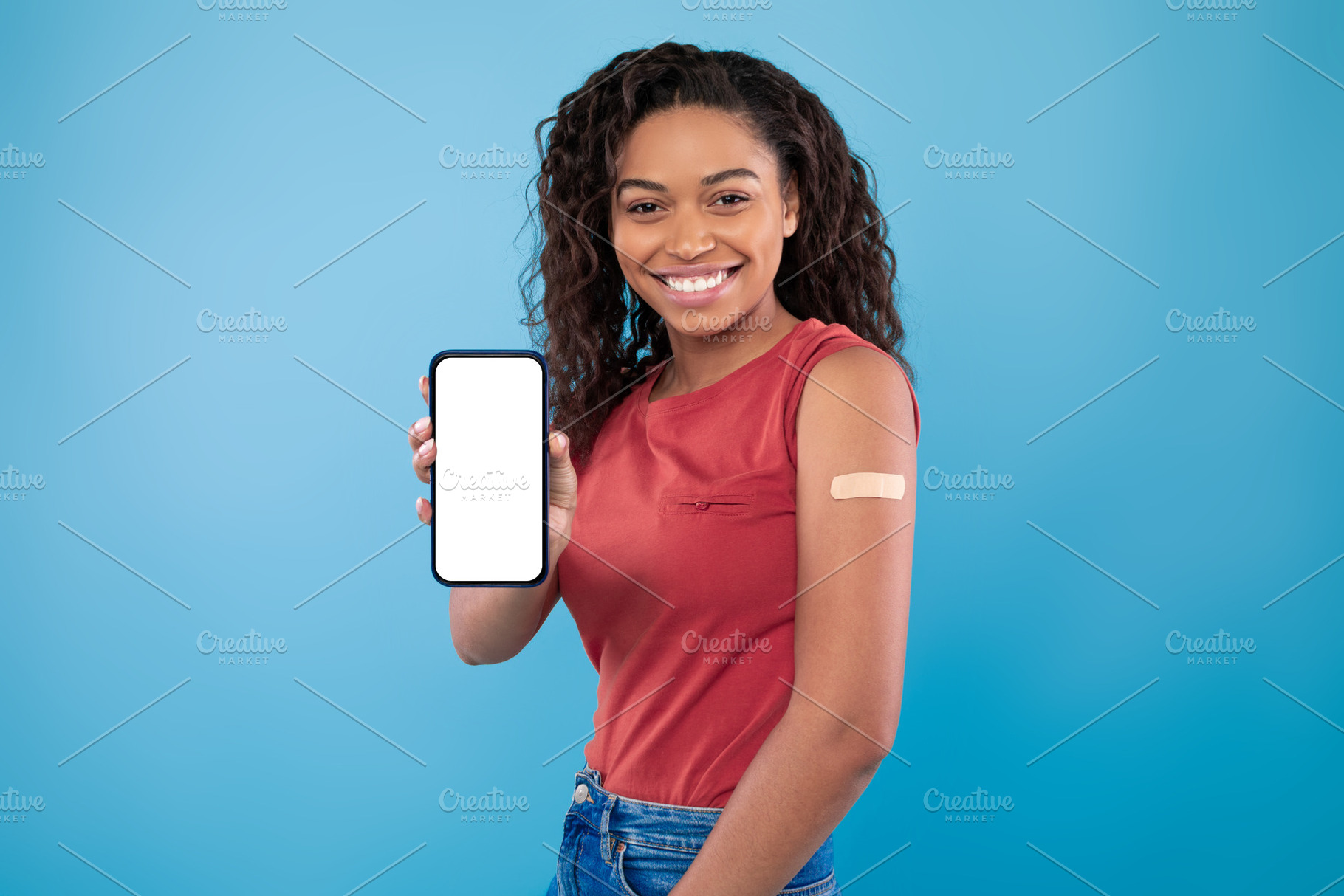 Young black woman with adhesive bandage showing empty smartphone with mockup fo, a Photo by Prostock-Studio