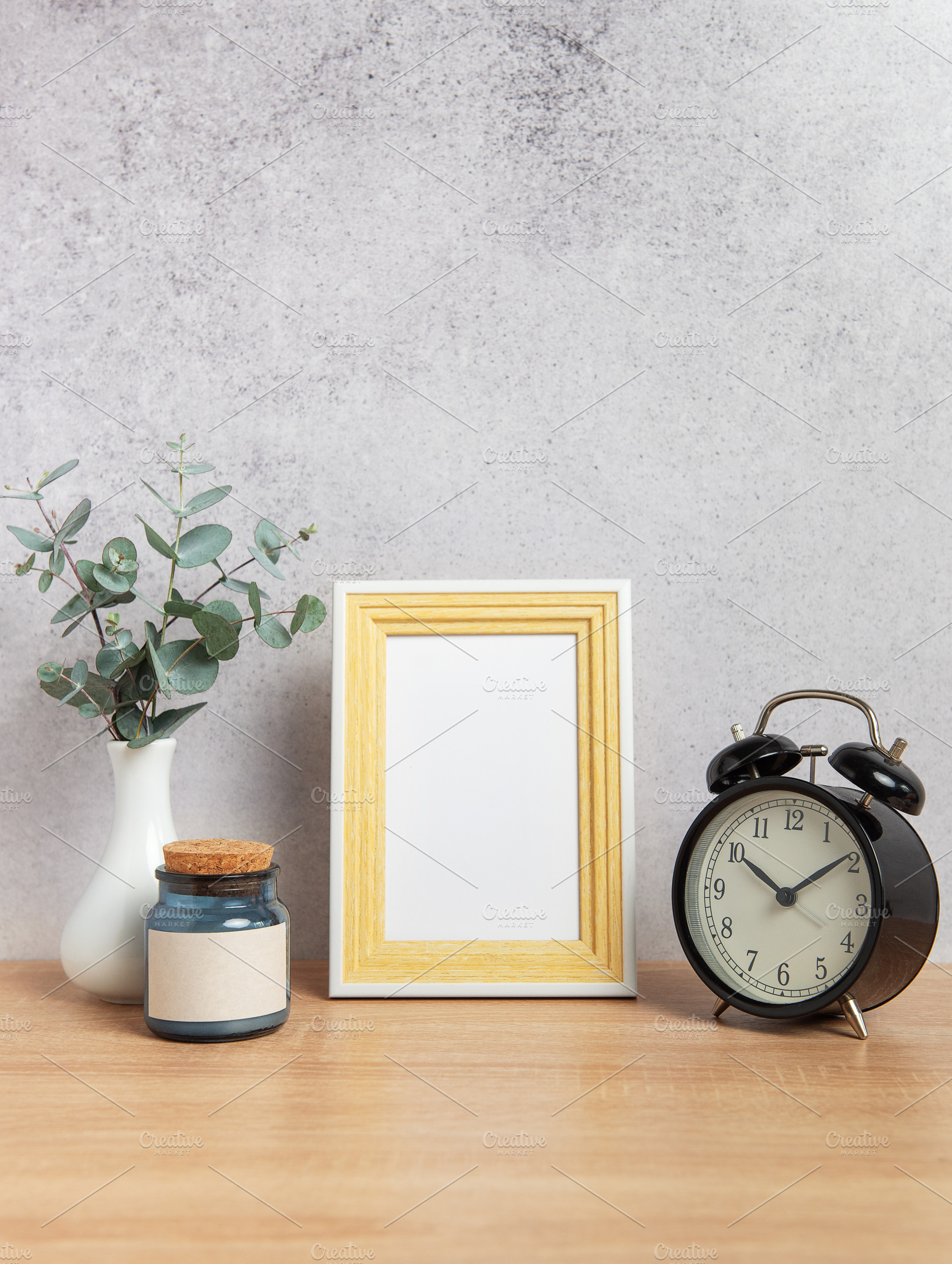 Empty photo frame, alarm clock, eucalyptus branches and jar on w, a Business Photo by Olena Rudo