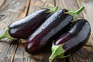 Fresh eggplants on wooden table, a Food & Drink Photo by AlyaAnd