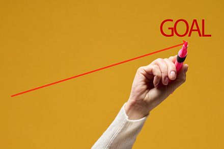 A hand draws a chart up with a red marker on a yellow background, an Abstract Photo by ndanko