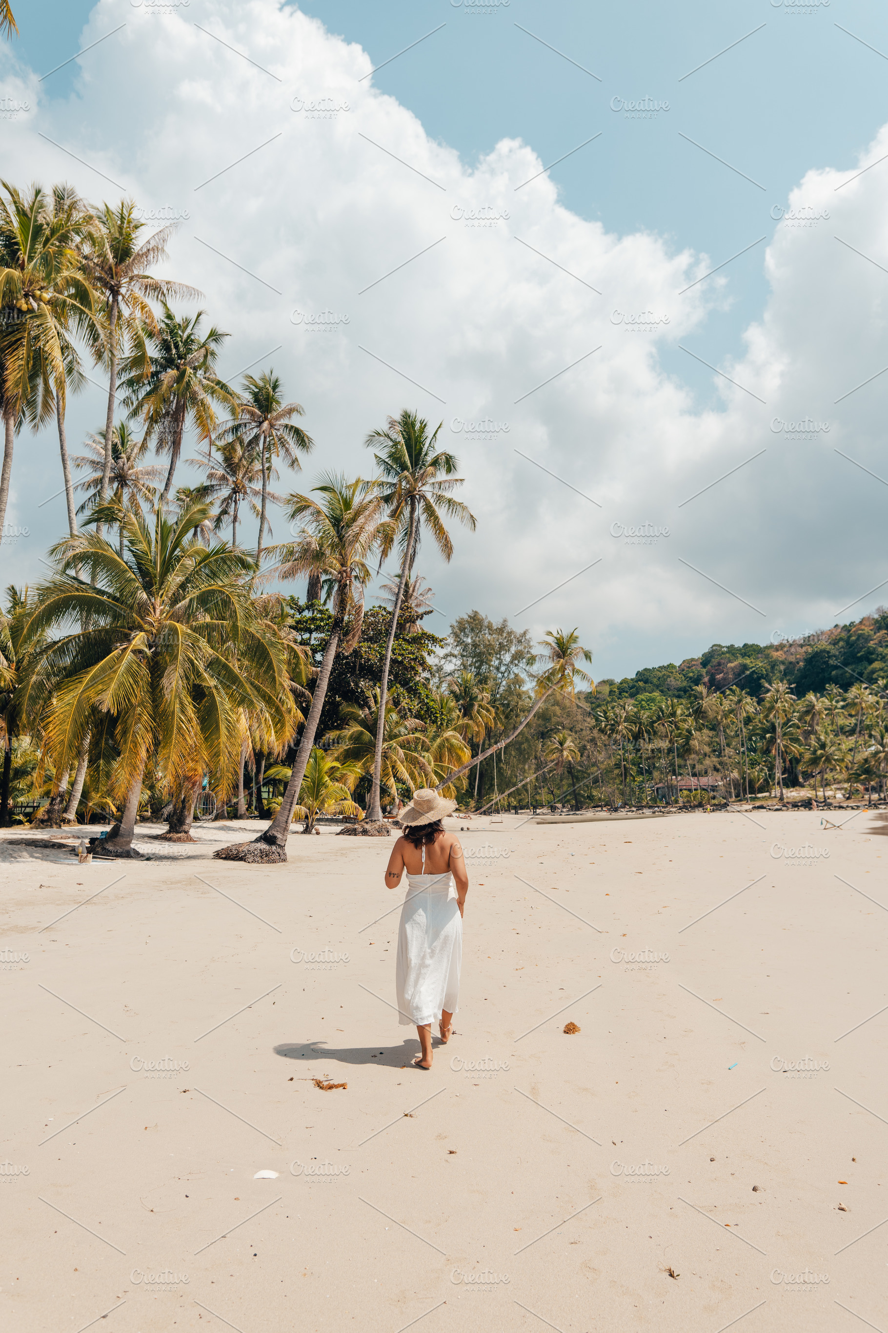 A woman in a hat enjoys the summer sun on a beautiful tropical b, a Holiday Photo by Art Rachen