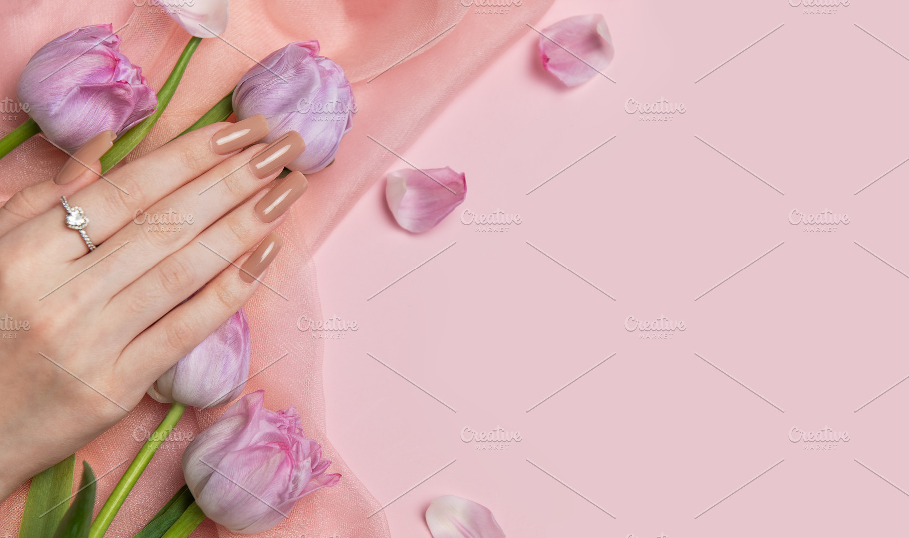 Woman showing stylish nude manicure with tulips on pink backgrou, a Beauty & Fashion Photo by Olena Rudo
