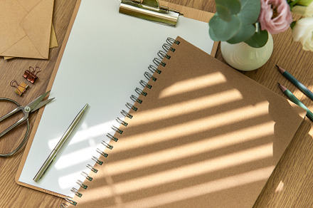 A workspace with stationery including a notepad, clipboard, and, a School & Education Photo by Olena Rudo