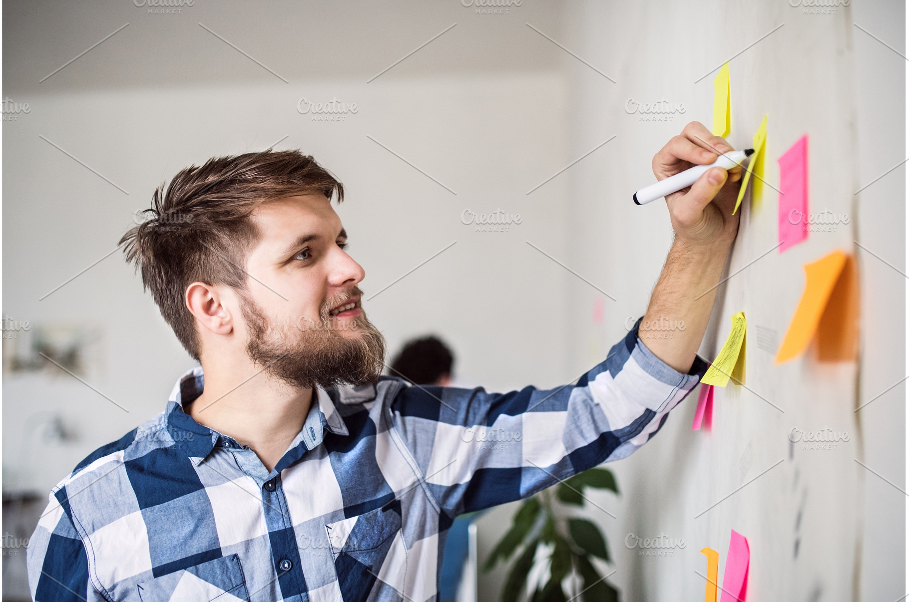 Man writing ideas on colorful sticky, a Business Photo by HalfPoint