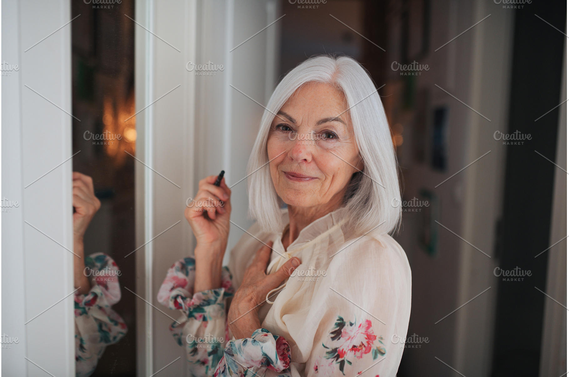 Senior woman applying makeup in, a Beauty & Fashion Photo by HalfPoint