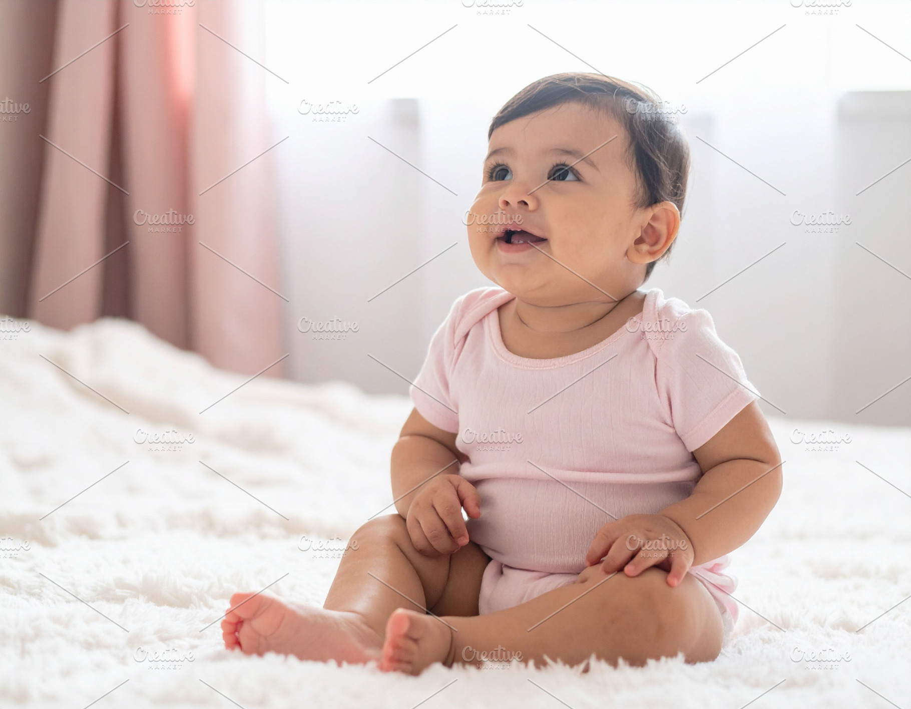Baby girl sitting on a soft blanket in a bright room, a Person Photo by DanFLCreativo