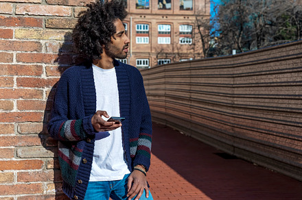 Young afro man using cellphone outdoor, a Person Photo by 2Design