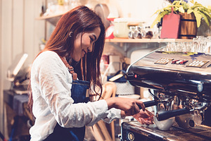 Professional female barista hand making cup of coffee with coffe