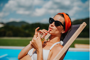 Young woman sitting by swimming pool