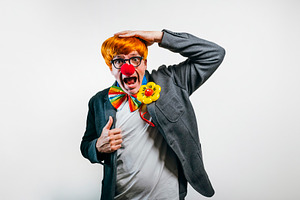 Mid adult man wearing clown costume experiencing surprise, a Person Photo by karrastock