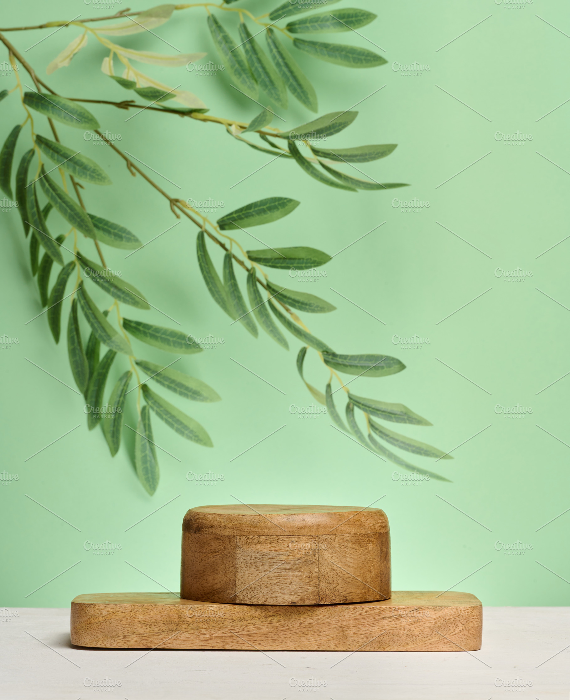 Wooden cylindrical podium or display stand sits on green backgro, a Background Photo by ndanko