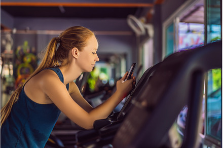 Young woman using phone while, a Sports & Recreation Photo by Elizaveta Galitskaya