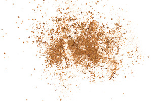 A scattering of ground nutmeg on a white background, top view, a Food & Drink Photo by ndanko
