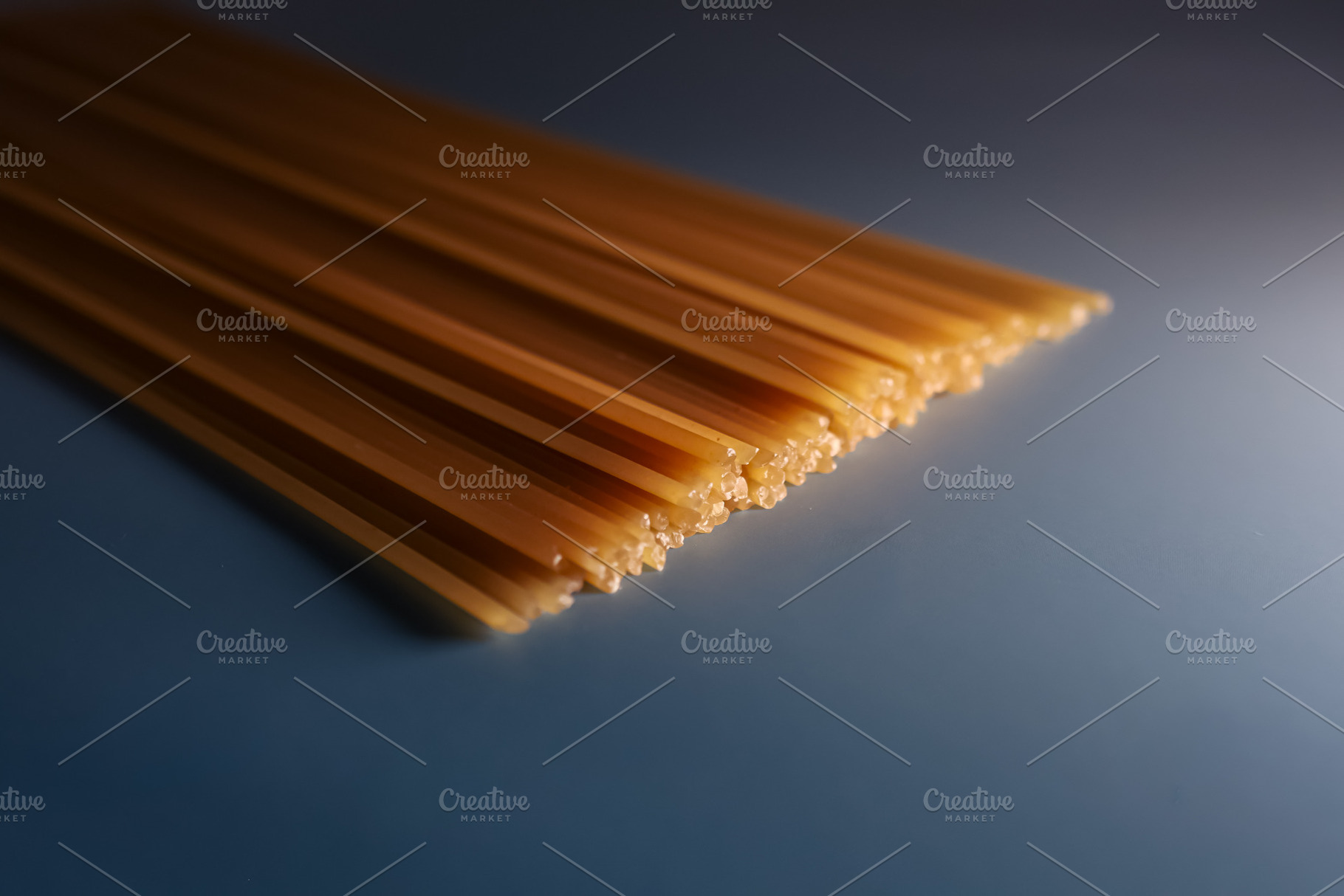 Spaghetti pasta raw durum wheat dry food on blue background with, a Photo by Studio ANNA