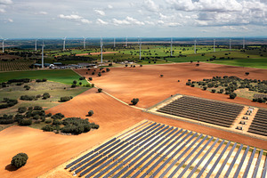 Aerial shot of solar panels and wind farms on vast field