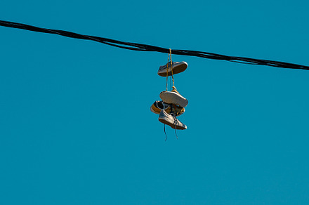 Sneakers hanging on a sky background