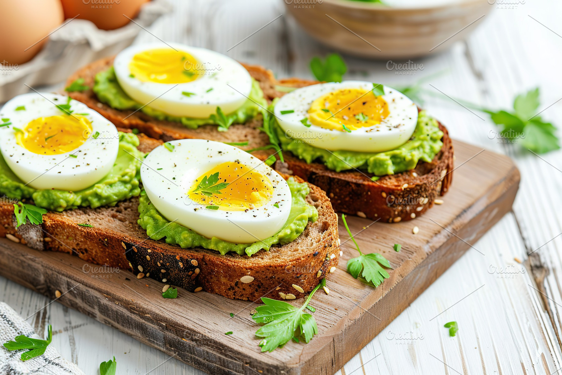 Toast rye bread with avocado puree and hard boiled eggs on wooden table, a Food & Drink Photo by AlyaAnd