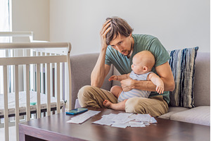 Father sitting on sofa holding baby