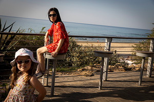Mother and daughter on a sunny day near the sea, mother sitting, a Person Photo by Imaginarium