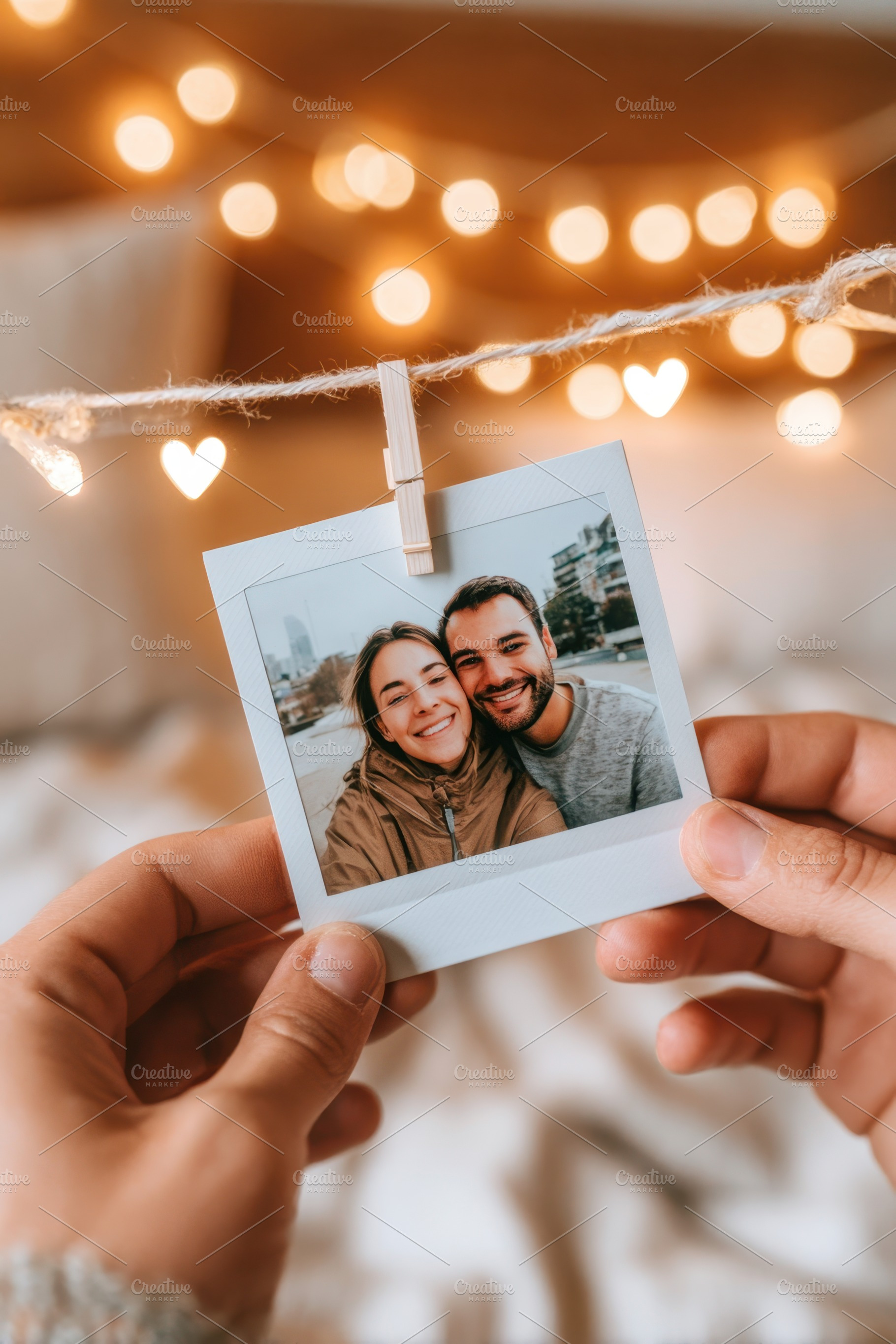 Couple holding a polaroid photo in a cozy setting, an Arts & Entertainment Photo by AlyaAnd