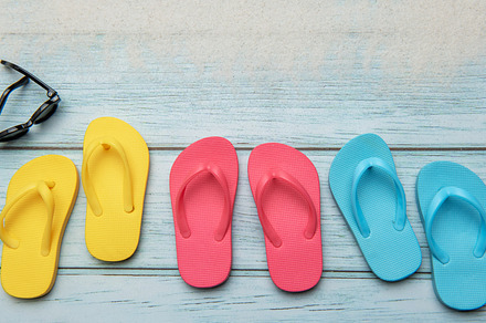 Colorful flip flops and sunglasses resting on beach boardwalk, e