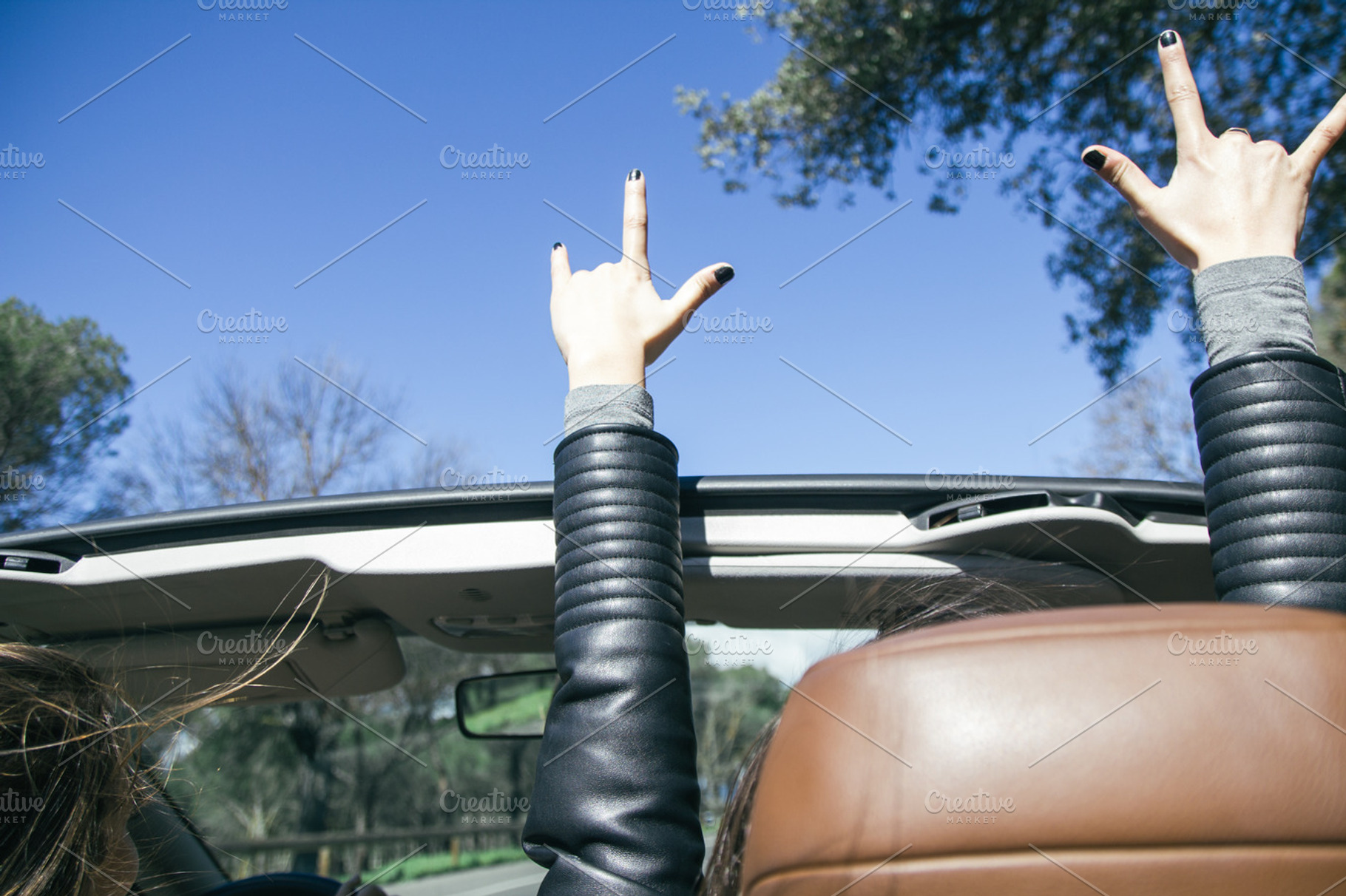 Hands of a woman in the air in a car featuring arms, automobile, and beauty, a Person Photo by Am.Benitez Estudio