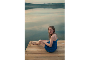 Woman in Blue Towel Sitting on Dock, a Person Photo by Jan Jack Russo Media